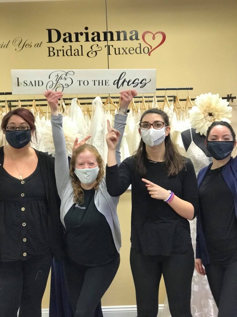 Four Darianna Bridal & Tuxedo Consultant Jess, Shannon, Courtney and Caitlyn, holding the I Said Yes To the Dress sign, ready for brides to find their wedding dress on a Sunday Funday