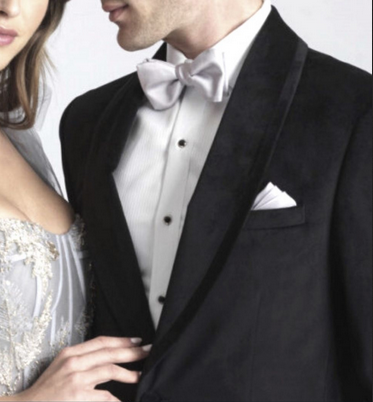 Black tuxedo with a thick shawl lapel and satin stripe, white shirt, bowtie, and pocket square