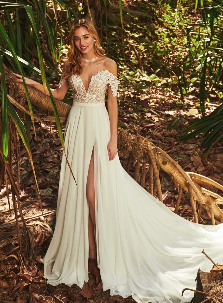Maisie dress by designer Calla Blanche from the L'Amour collection, this wedding dress has a lace bodice with a plunge neckline and off the shoulder lace sleeves, a satin belted waist and a beautiful chiffon skirt with a slit