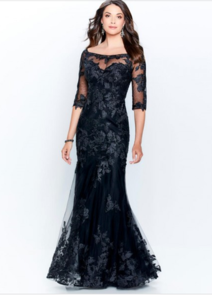 Mother of the bride dress from Mon Cheri Montage line with an off the shoulder neck line, three-quarter inch sleeves and all over lace appliqué, shown in black comes in delphinium as well