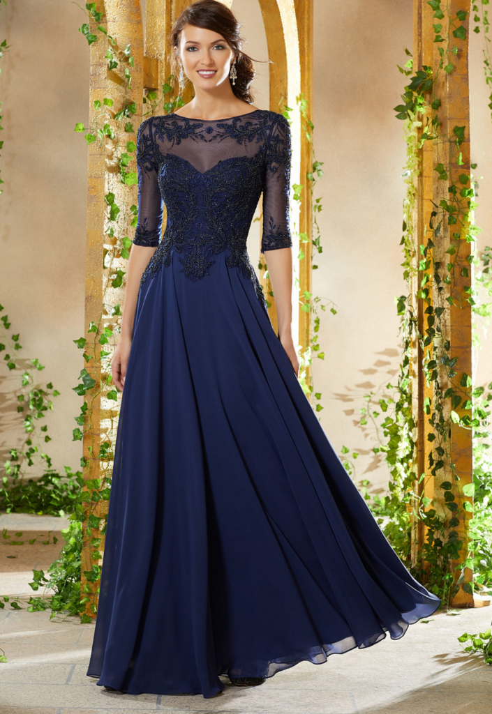 Navy mother of the bride dress with a boat neckline, beaded illusion top and three-quarter inch sleeves and a layered chiffon skirt