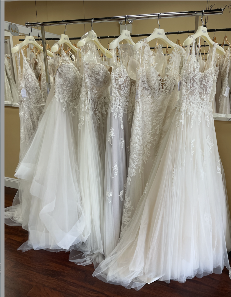 Opening and displaying trunk show wedding dresses from designer Morilee with lace and tulle in ivory and blush colors