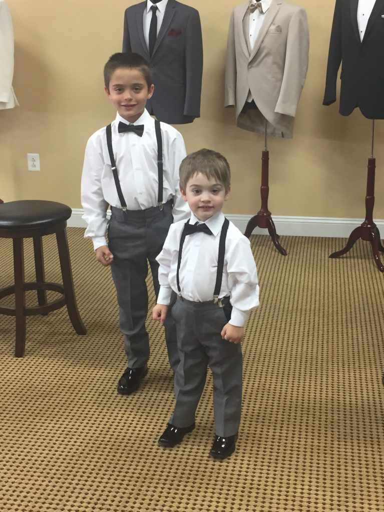Brothers and ring bearers are dressed for the wedding in suspenders and bowties