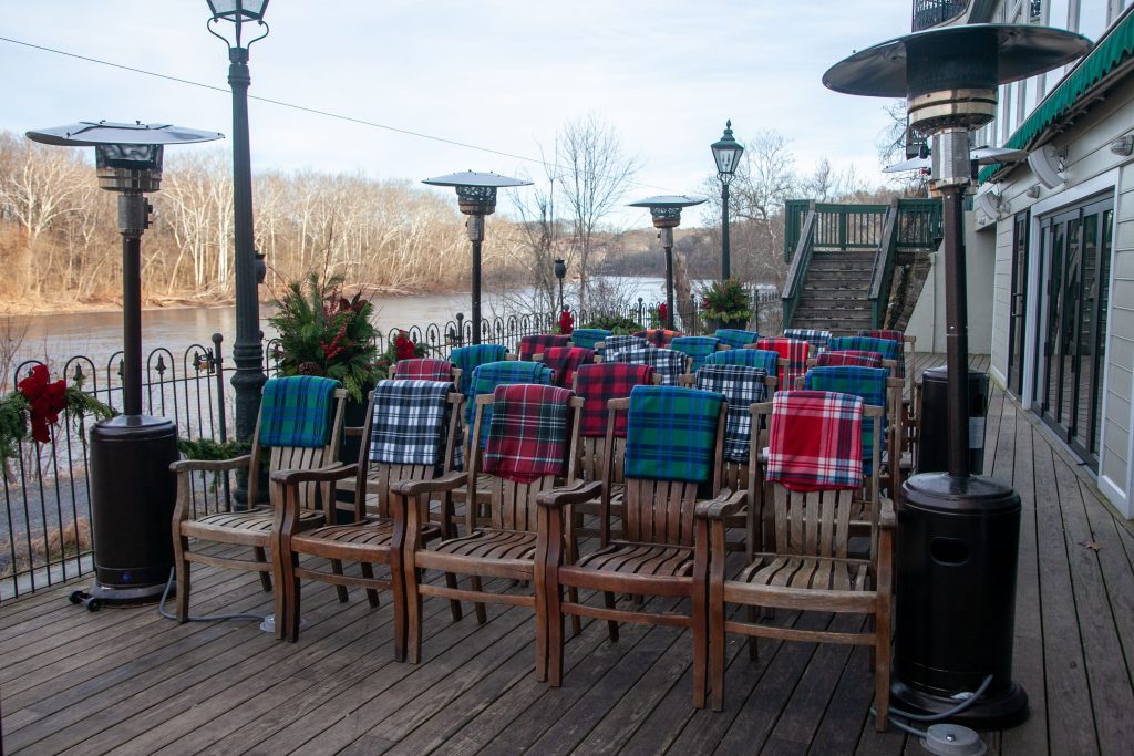 Ceremony set up before guests arrive with heat lamps and chairs with plaid blankets draped over the backs