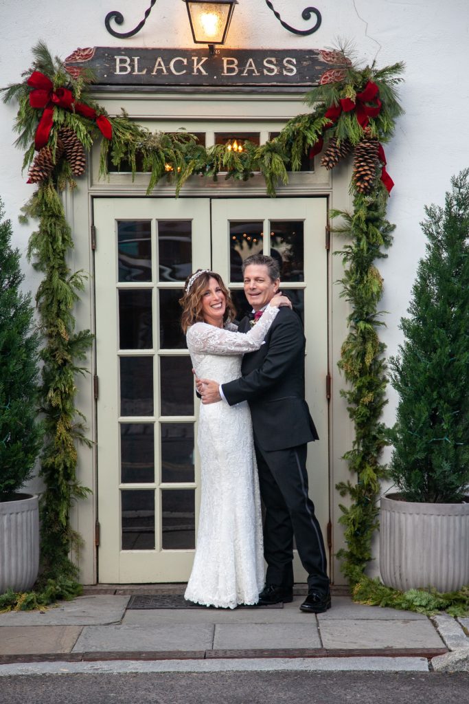 Bride and groom in front of the black bass hotel decorated for Christmas
