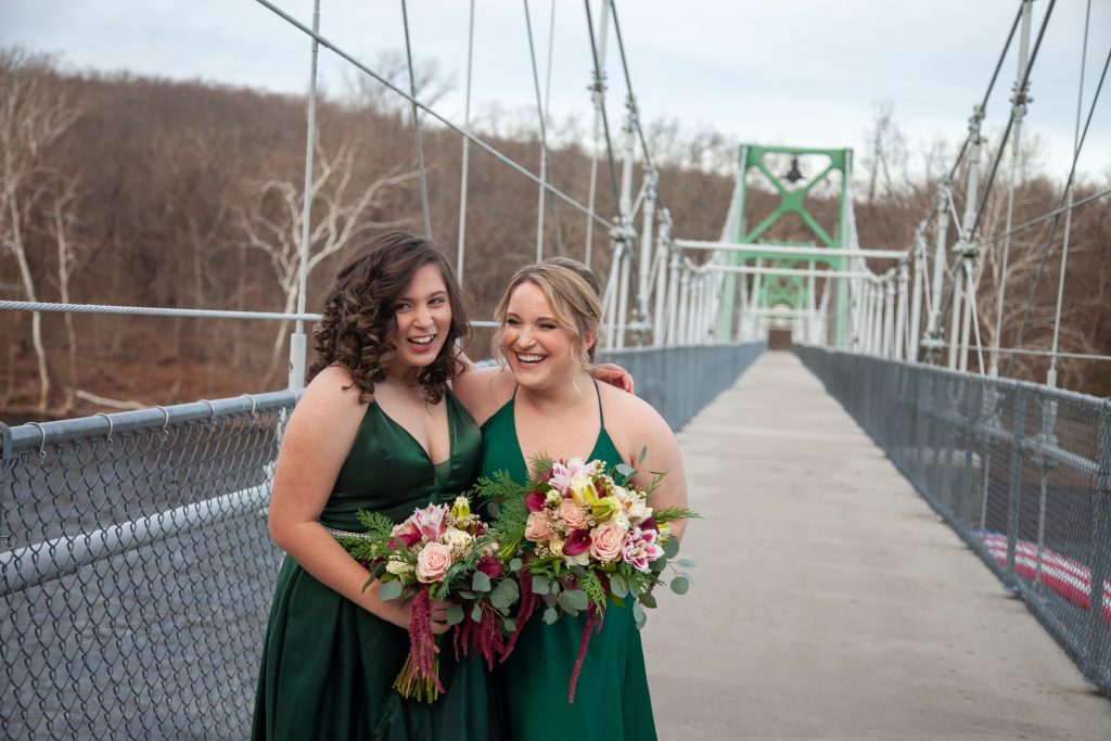 Maids of honor wearing hunter green satin dresses by Clarisse