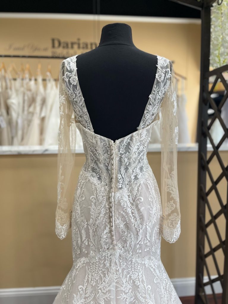 The back of the Dauphine wedding dress when worn with the sleeves has a dramatic squared back that lead perfectly into the button covered zip closure