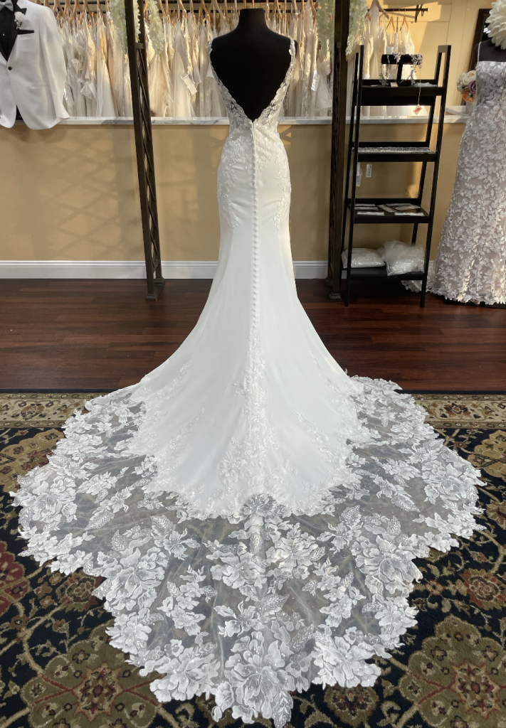 Gorgeous back view of Stella York 7457 with a low V-back, inset lace over matte satin, and buttons down the length of the train