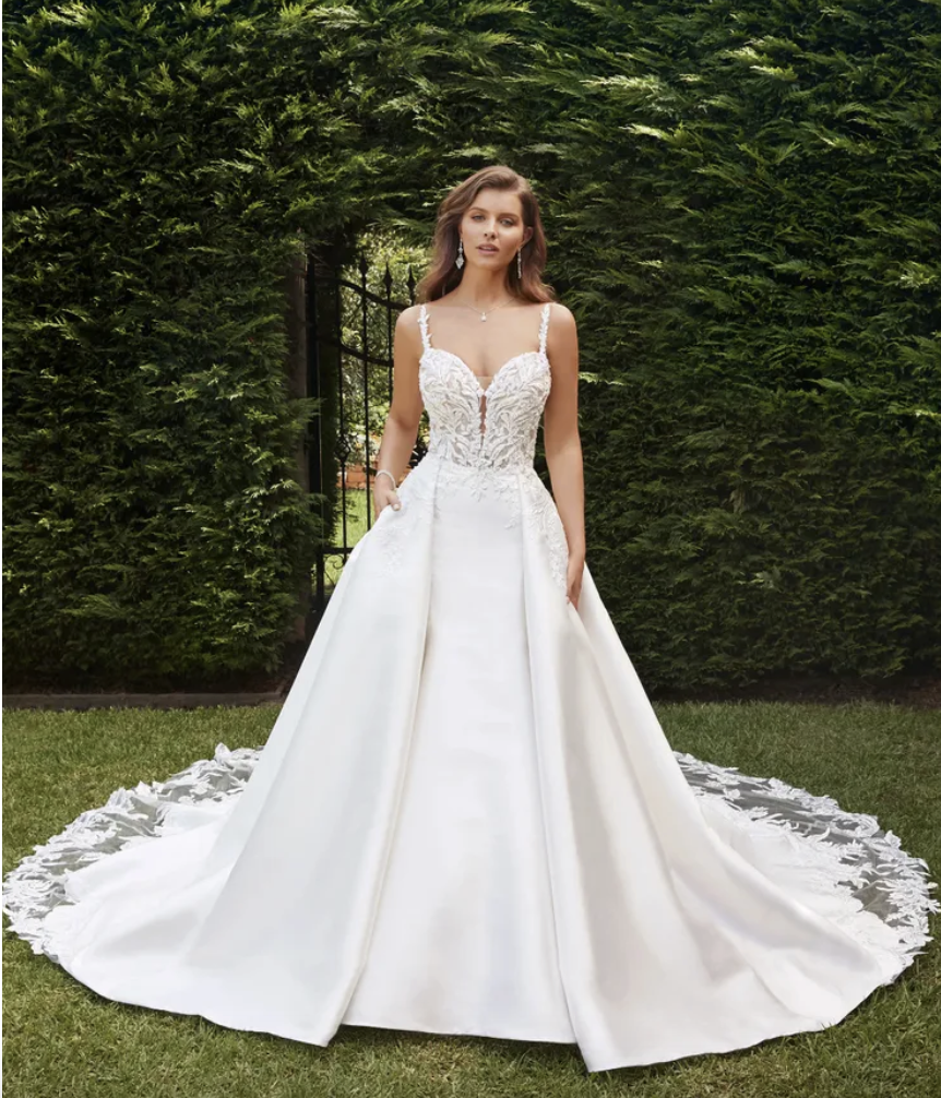 Zuri wedding dress Sophia Tolli is a mikado fit and flare with lace straps, beaded bodice lace, scooped low back buttons that run the length of the illusion lace train and an optional detachable mikado and lace overskirt