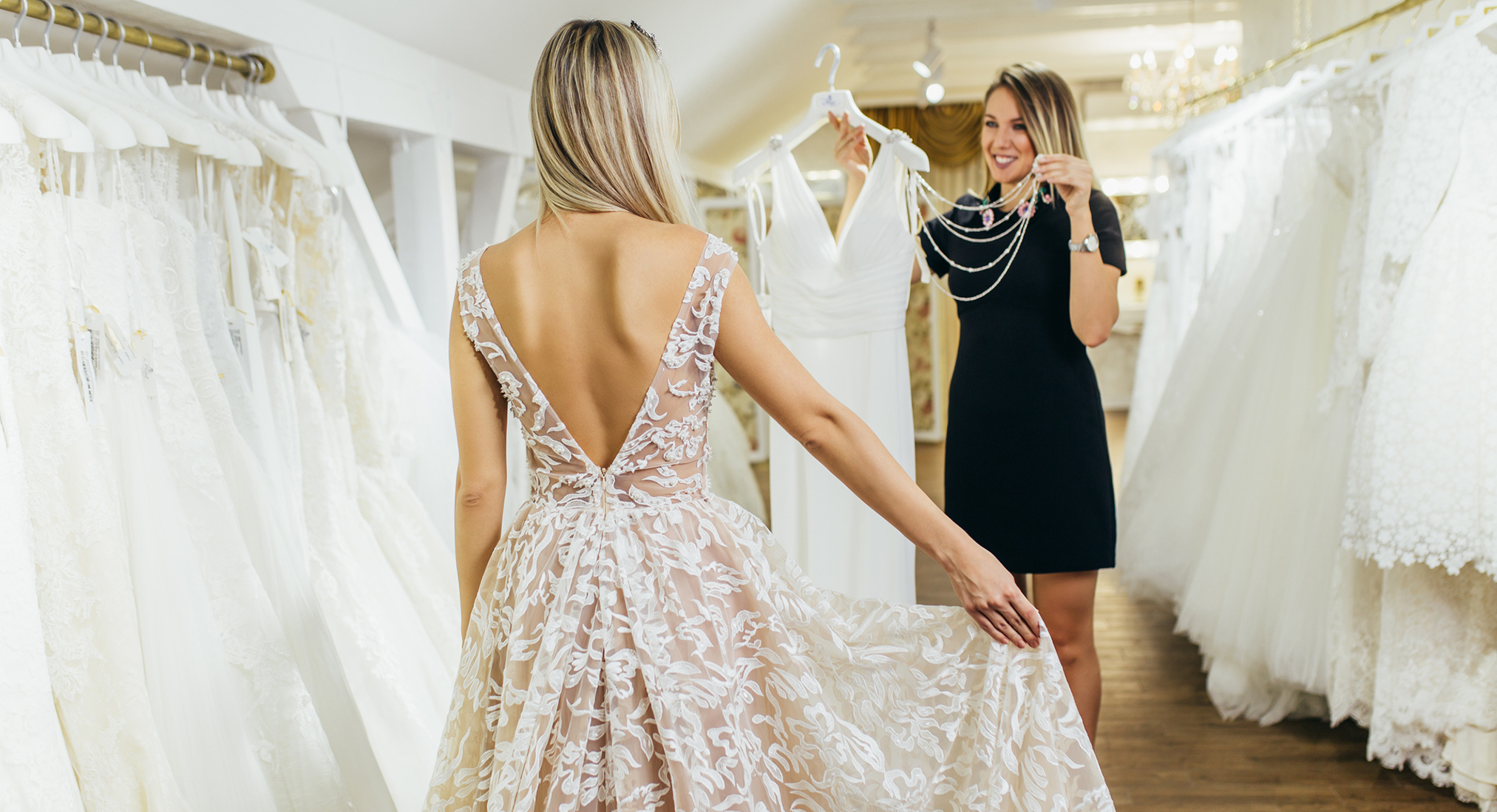 Beautiful young woman choosing a wedding dress in a modern wedding salon.