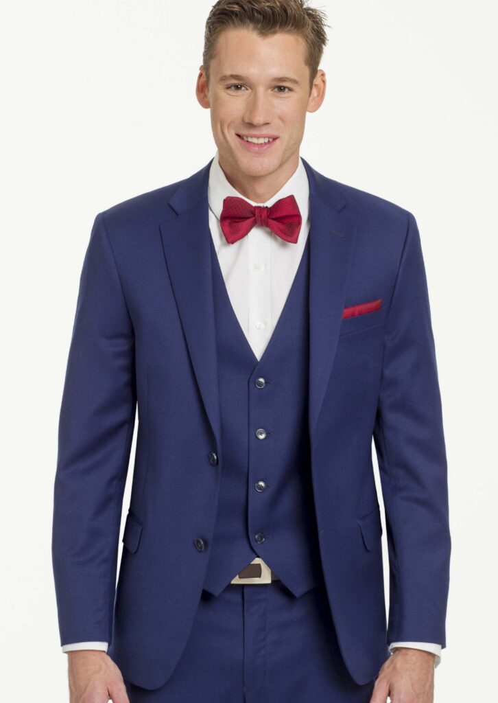 Model and a three-piece, bright blue suit, jacket with notch Labelle, matching best, white shirt, red bowtie, and matching pocket square