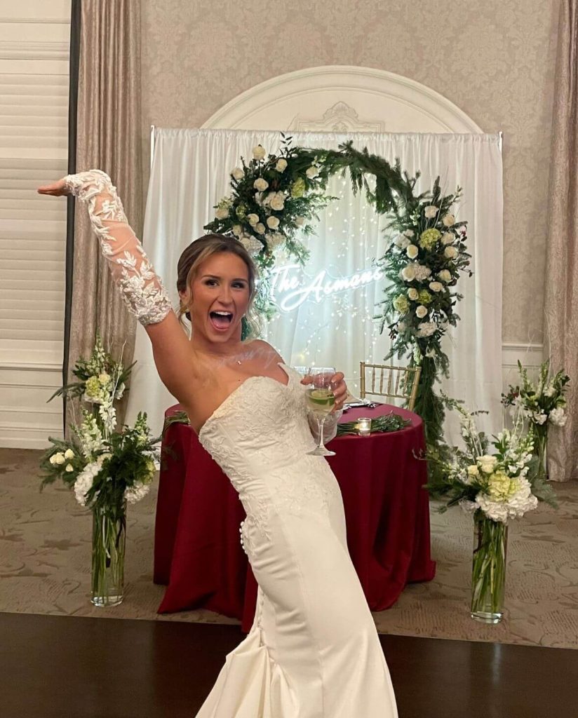 Bride showing a detachable lace sleeve alteration on her fitted wedding gown at the reception