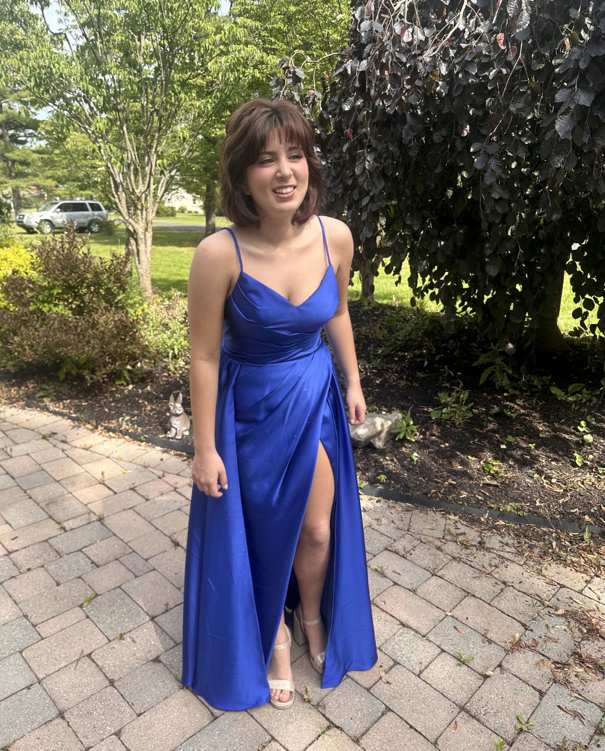 Woman wearing a tailored royal blue formal dress with spaghetti straps and a leg slit outdoors afterformal wear alterations in PA
