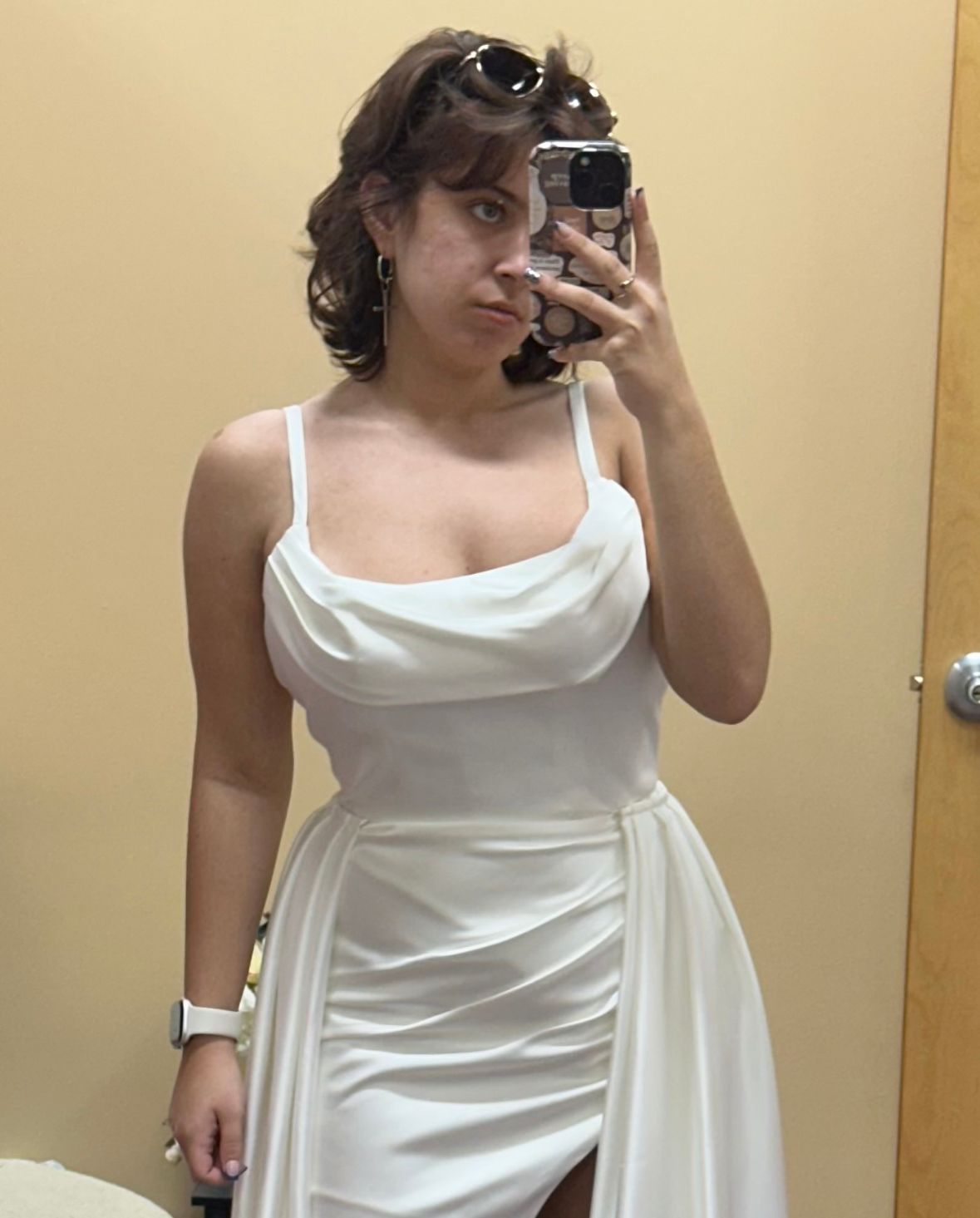Bride taking a mirror selfie in a short white wedding dress with a detachable overskirt alterations completed in PA