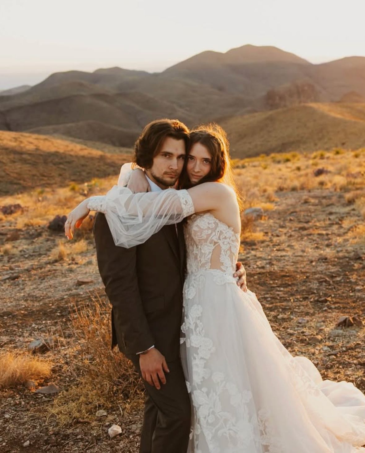 Bride and groom posing in the mountains on wedding day after formal wear alterations in PA