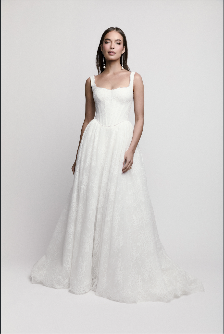 Bride modeling square-neck lace A-line wedding dress with fitted bodice and flowing skirt