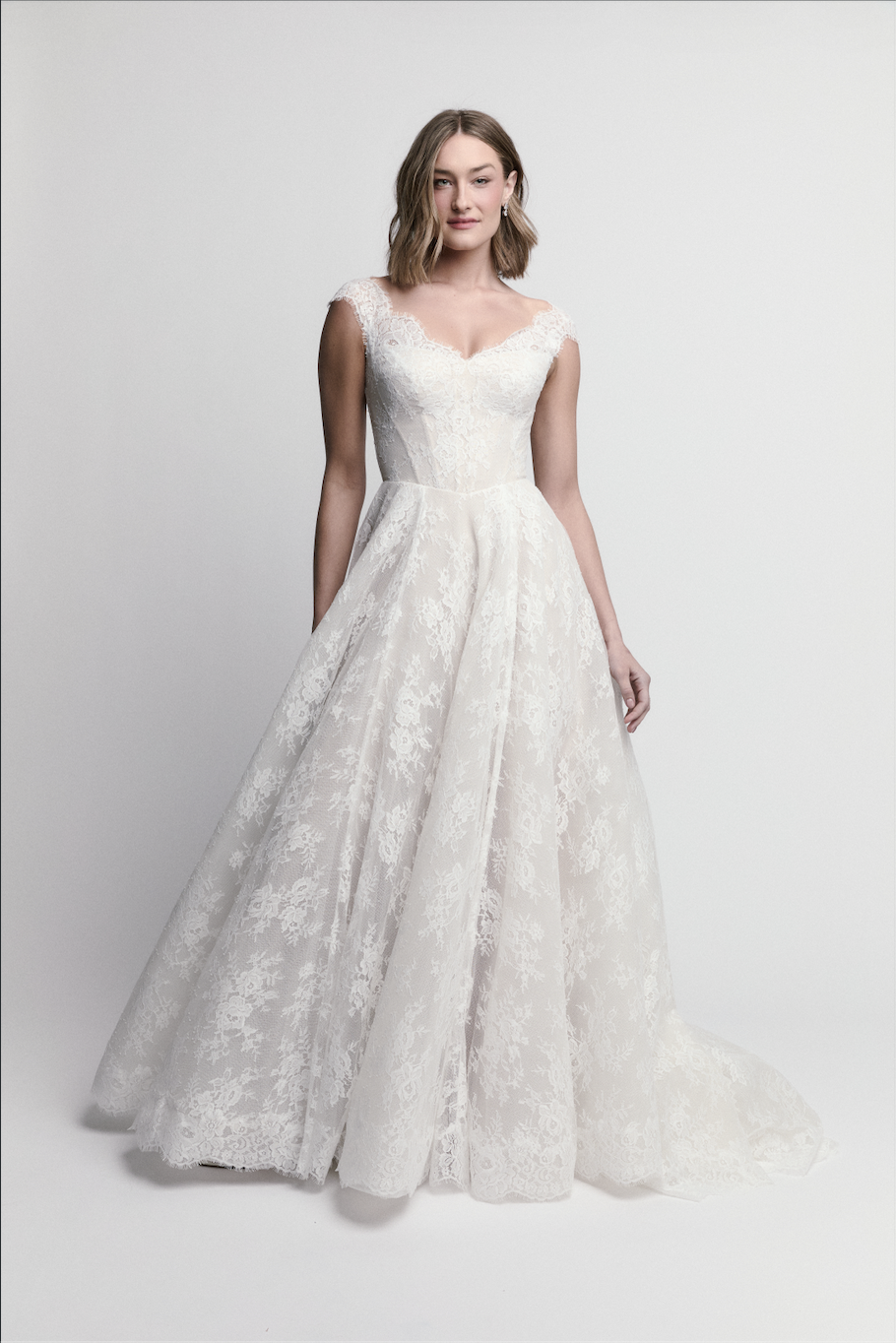 Bride modeling cap-sleeve lace ball gown by WToo by Watters with full skirt and romantic train